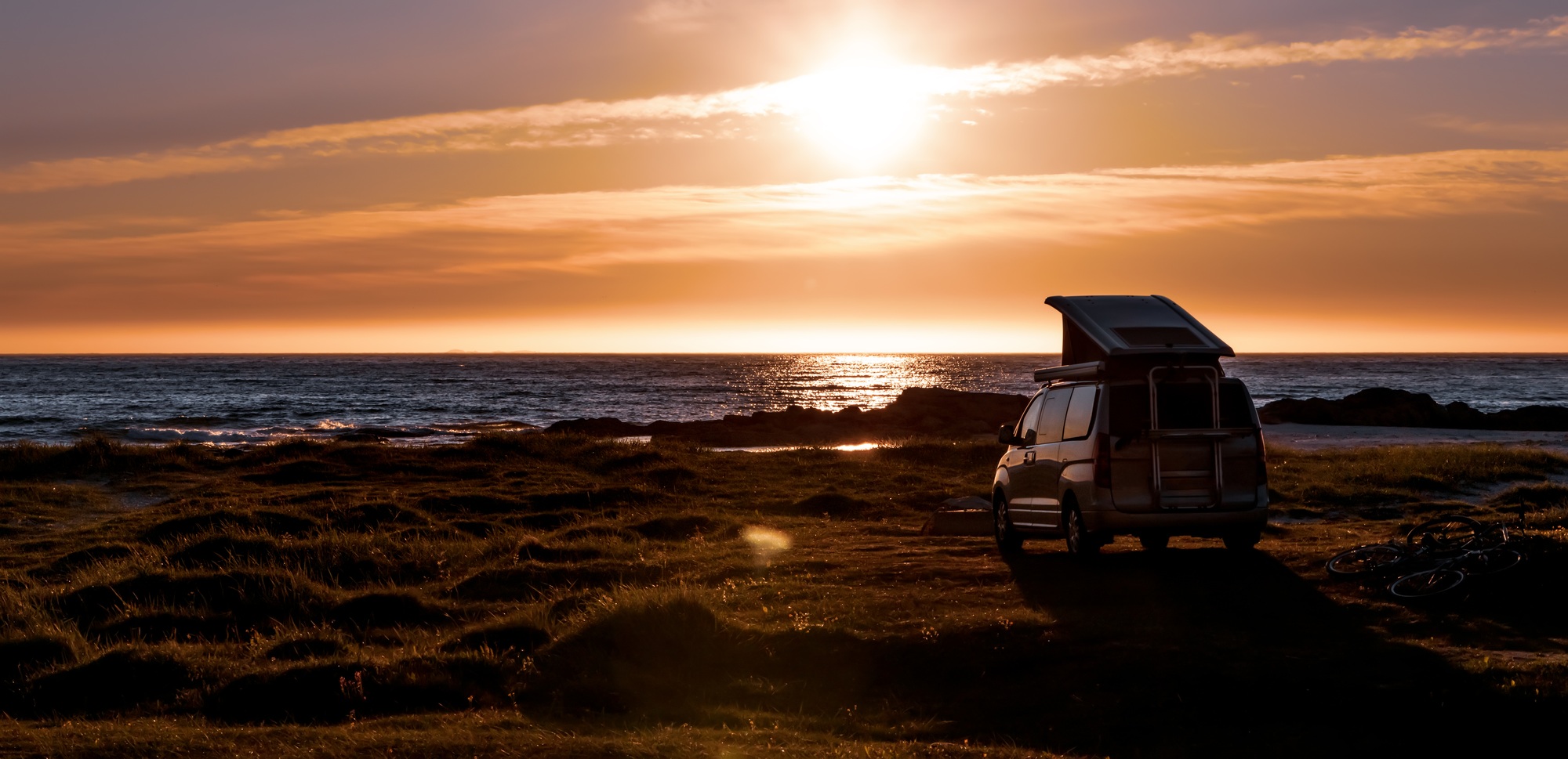 Coucher de soleil sur la plage avec le van aménagé Camp'n Dream